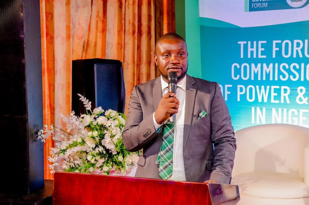 Abayomi with a microphone on stage